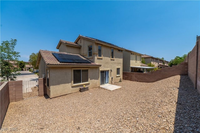 1453 Evening Song Ave, Henderson, NV 89012 - rear view of house with roof mounted solar panels, stucco siding, a fenced backyard, and a tiled roof