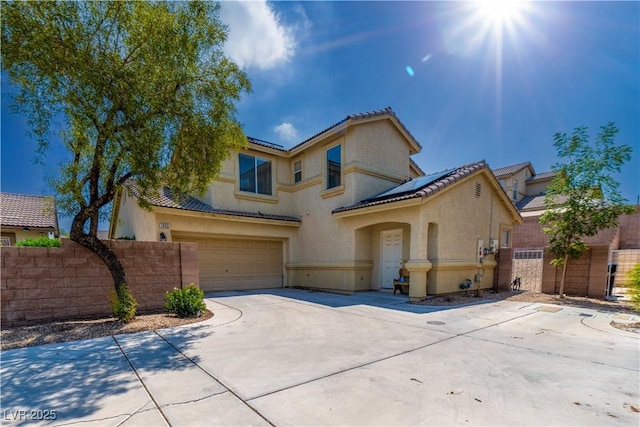 1453 Evening Song Ave, Henderson, NV 89012 - mediterranean / spanish house featuring roof mounted solar panels, an attached garage, driveway, stucco siding, and a tiled roof