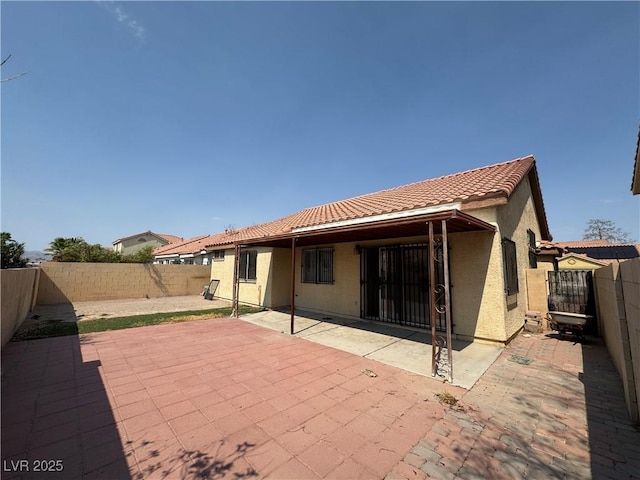 2503 River Oaks Dr, Las Vegas, NV 89156 - rear view of house featuring a tile roof, stucco siding, a fenced backyard, and a patio