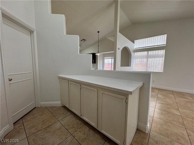 2503 River Oaks Dr, Las Vegas, NV 89156 - kitchen with light tile patterned floors, a peninsula, lofted ceiling, light countertops, and hanging light fixtures