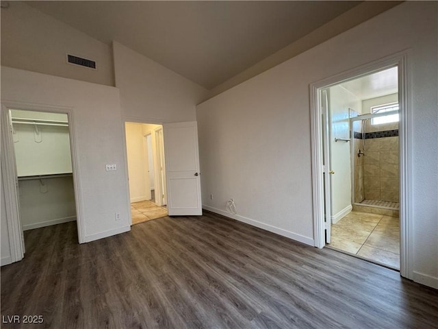 2503 River Oaks Dr, Las Vegas, NV 89156 - unfurnished bedroom with a walk in closet, dark wood-style floors, high vaulted ceiling, and ensuite bathroom