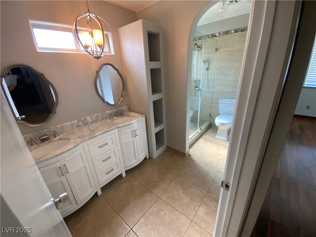 5753 E Monroe Ave, Las Vegas, NV 89110 - bathroom with a shower stall, double vanity, a chandelier, and tile patterned floors
