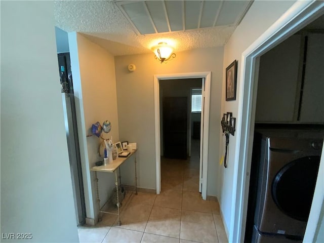 5753 E Monroe Ave, Las Vegas, NV 89110 - laundry area with washer / clothes dryer, light tile patterned flooring, and a textured ceiling