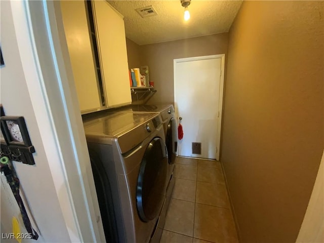 5753 E Monroe Ave, Las Vegas, NV 89110 - laundry area featuring washing machine and clothes dryer, a textured ceiling, and light tile patterned floors