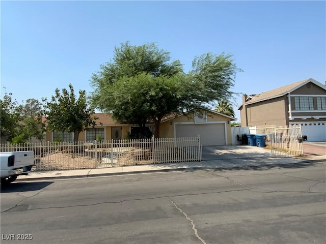 5753 E Monroe Ave, Las Vegas, NV 89110 - view of front of house with driveway, a fenced front yard, stucco siding, and a garage