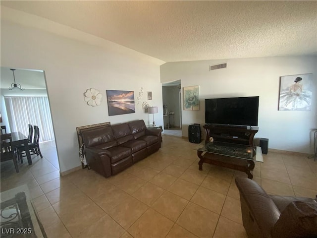5753 E Monroe Ave, Las Vegas, NV 89110 - living room featuring lofted ceiling, light tile patterned floors, and a textured ceiling
