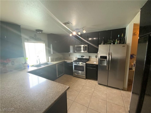 5753 E Monroe Ave, Las Vegas, NV 89110 - kitchen featuring stainless steel appliances, a textured ceiling, light tile patterned flooring, light countertops, and dark cabinetry
