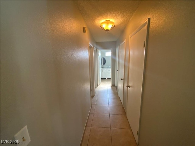 5753 E Monroe Ave, Las Vegas, NV 89110 - hallway with a textured wall, a textured ceiling, and light tile patterned flooring