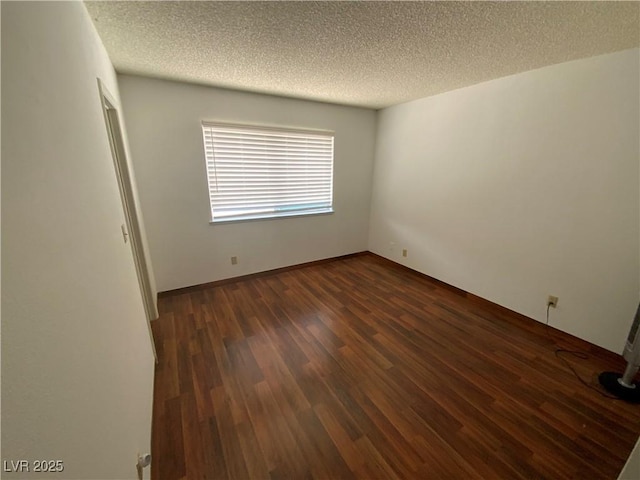 5753 E Monroe Ave, Las Vegas, NV 89110 - empty room with a textured ceiling and dark wood-type flooring