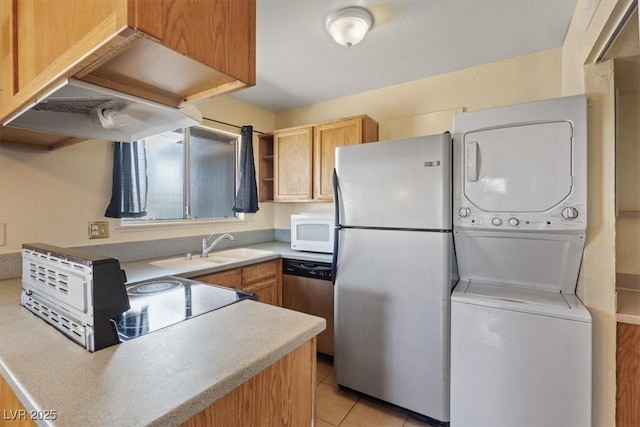 1481 Lorilyn Ave Unit 1, Las Vegas, NV 89119 - kitchen featuring estacked washer and dryer, freestanding refrigerator, light countertops, stainless steel dishwasher, and white microwave