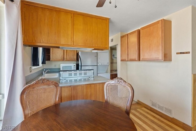 1481 Lorilyn Ave Unit 1, Las Vegas, NV 89119 - kitchen with freestanding refrigerator, a peninsula, white microwave, ceiling fan, and washer / dryer