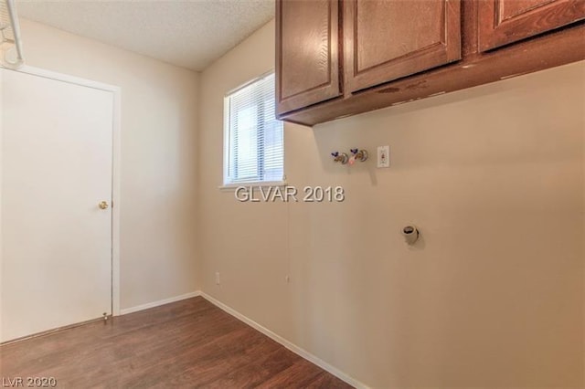 laundry area with a textured ceiling, cabinets, hardwood / wood-style floors, and hookup for a washing machine