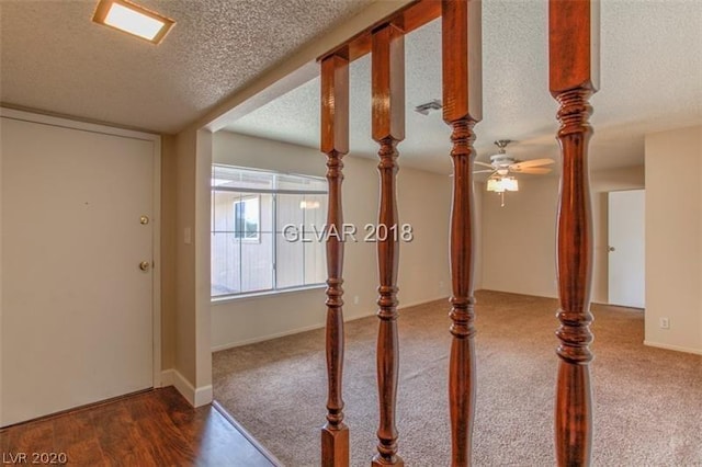 carpeted spare room with a textured ceiling and ceiling fan