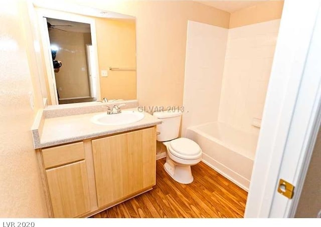 full bathroom featuring toilet, ceiling fan, shower / bath combination, hardwood / wood-style floors, and vanity