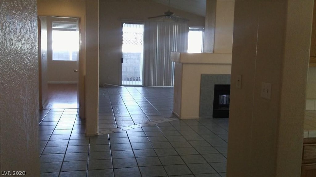 6520 Lombard Dr, Las Vegas, NV 89108 - unfurnished living room with plenty of natural light, dark tile floors, ceiling fan, and vaulted ceiling