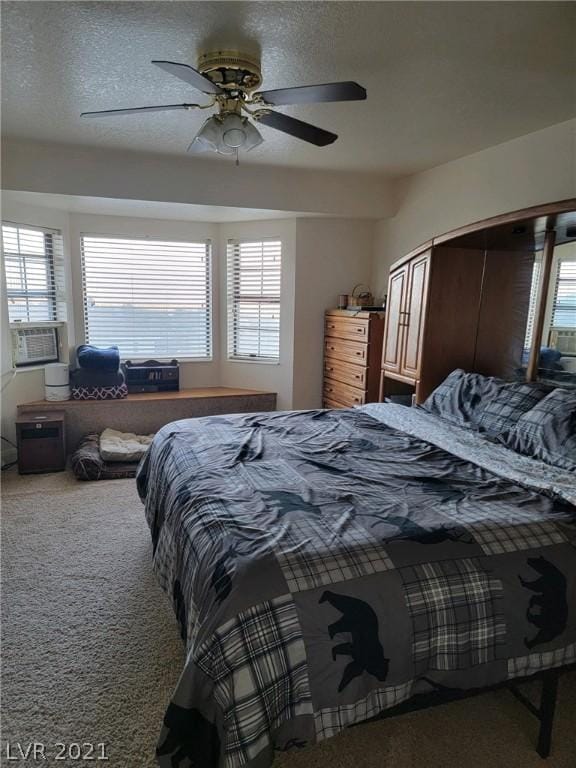 carpeted bedroom with a textured ceiling and ceiling fan