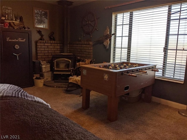 rec room featuring dark carpet and a wood stove