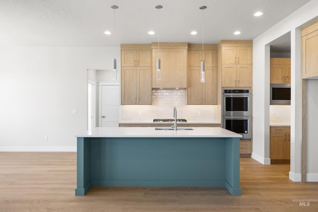 1351 E Andes Dr, Kuna, ID 83634 - kitchen featuring stainless steel appliances, decorative backsplash, light countertops, light wood finished floors, and a kitchen island with sink