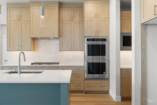 1351 E Andes Dr, Kuna, ID 83634 - kitchen featuring stainless steel appliances, a sink, light countertops, decorative backsplash, and light wood-style floors