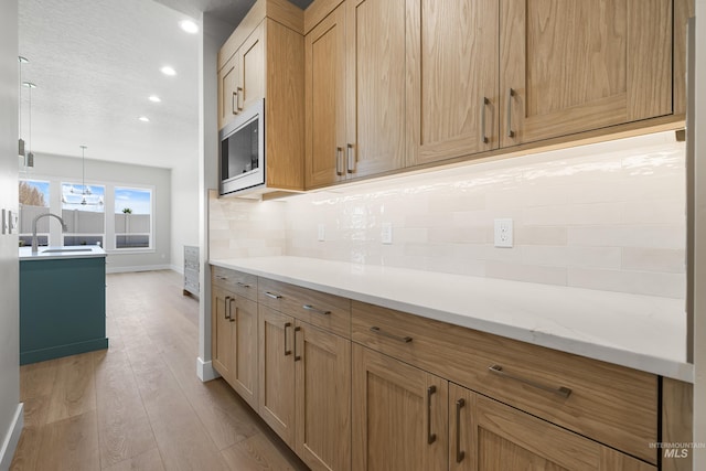 1351 E Andes Dr, Kuna, ID 83634 - kitchen featuring a sink, stainless steel microwave, light wood-type flooring, light countertops, and recessed lighting