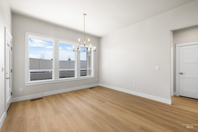 1351 E Andes Dr, Kuna, ID 83634 - unfurnished dining area featuring a chandelier, light wood-style flooring, and baseboards