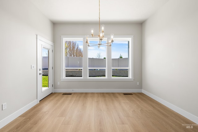 1351 E Andes Dr, Kuna, ID 83634 - unfurnished dining area featuring a chandelier, light wood-style flooring, and baseboards