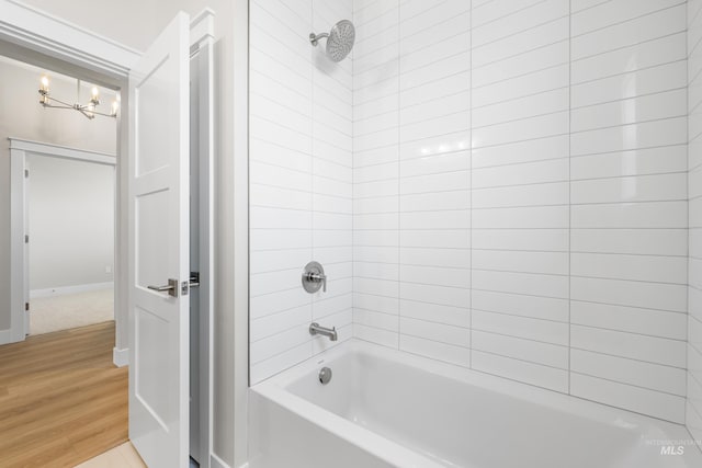 1351 E Andes Dr, Kuna, ID 83634 - full bathroom with a chandelier, wood finished floors, tub / shower combination, and baseboards