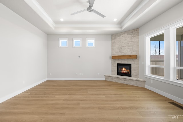 1351 E Andes Dr, Kuna, ID 83634 - unfurnished living room with a tray ceiling, a ceiling fan, a fireplace, light wood-style flooring, and recessed lighting
