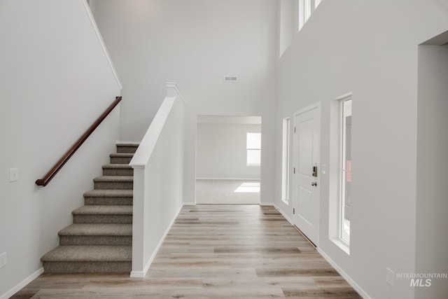 entryway featuring light wood-type flooring and a high ceiling