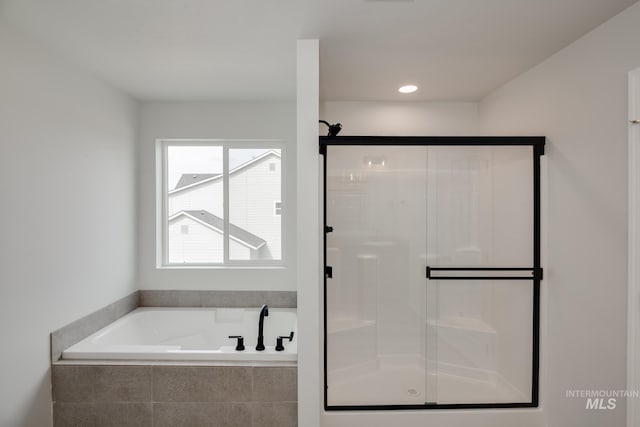 bathroom featuring independent shower and bath