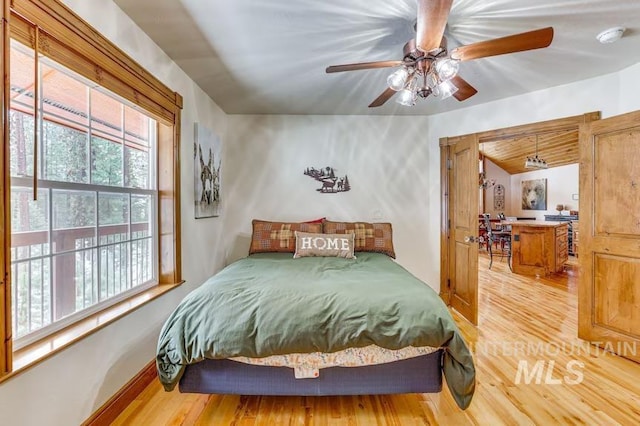 bedroom featuring light wood-style flooring, ceiling fan, and vaulted ceiling