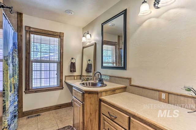 bathroom featuring tile patterned floors, plenty of natural light, and visible vents