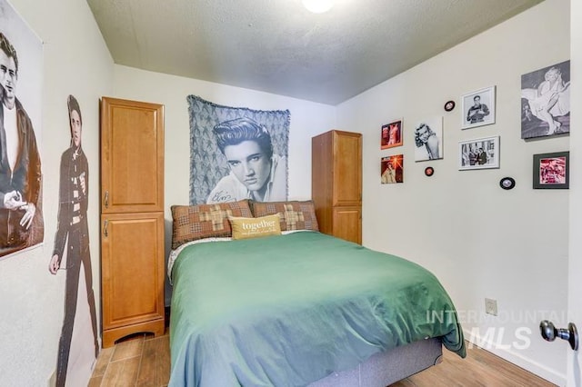 bedroom with light wood-style floors and baseboards
