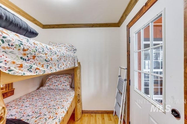 bedroom featuring crown molding, baseboards, and light wood finished floors