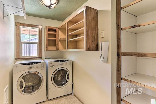 laundry area featuring separate washer and dryer and cabinet space