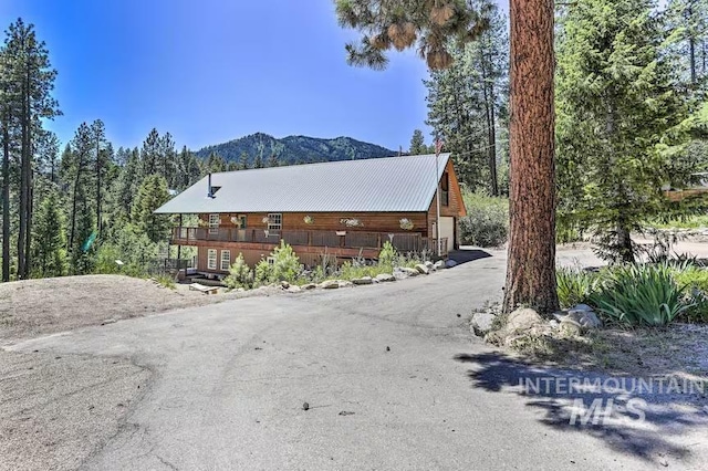 view of property exterior with metal roof and a mountain view