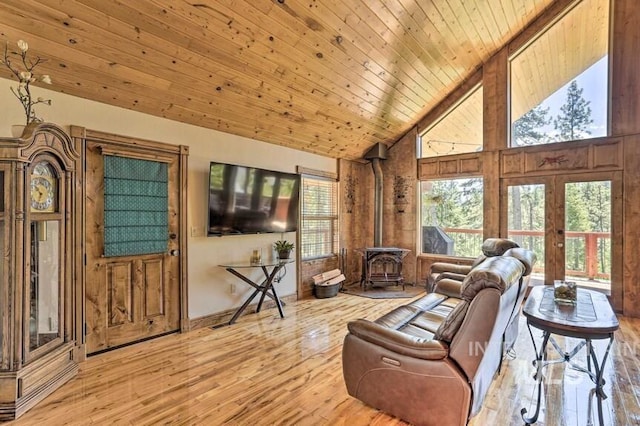 living area with french doors, wooden ceiling, high vaulted ceiling, wood finished floors, and a wood stove