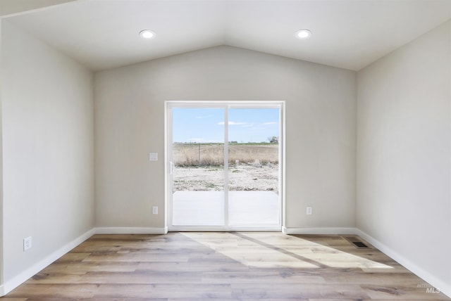 empty room with baseboards, lofted ceiling, and wood finished floors