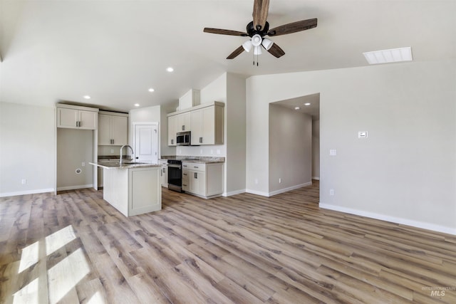 kitchen featuring range with electric cooktop, stainless steel microwave, open floor plan, lofted ceiling, and visible vents