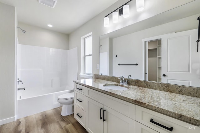 bathroom featuring vanity, shower / bathtub combination, toilet, wood finished floors, and visible vents
