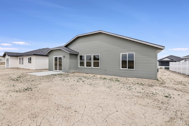 rear view of house with fence and a patio