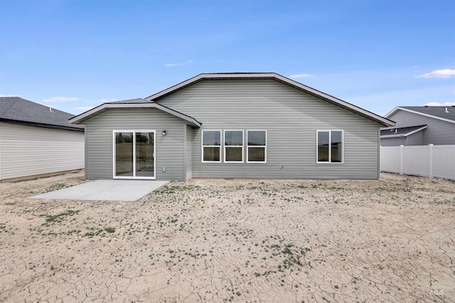 back of property with fence and a patio area