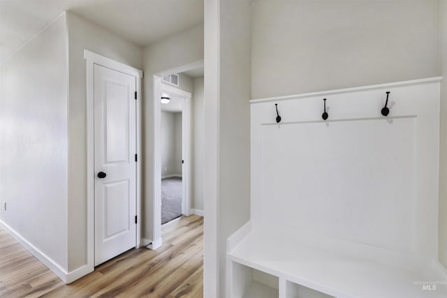mudroom featuring light wood-type flooring, baseboards, and visible vents