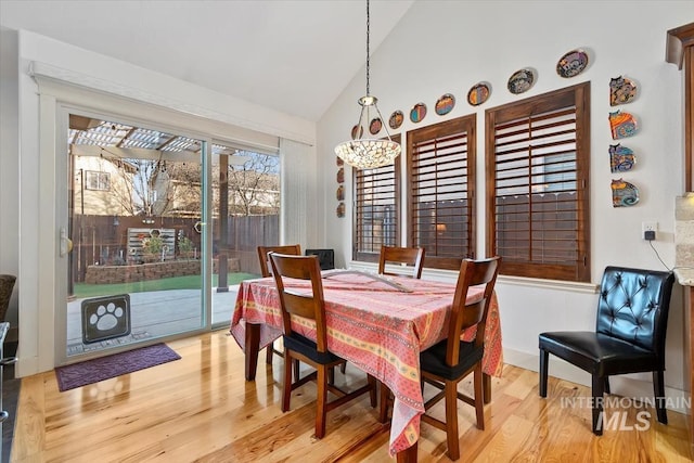 dining space featuring lofted ceiling and light wood-type flooring