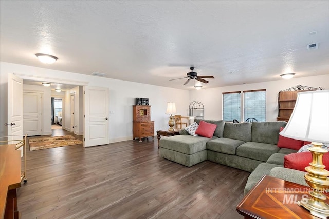 living room featuring a textured ceiling, dark hardwood / wood-style floors, and ceiling fan