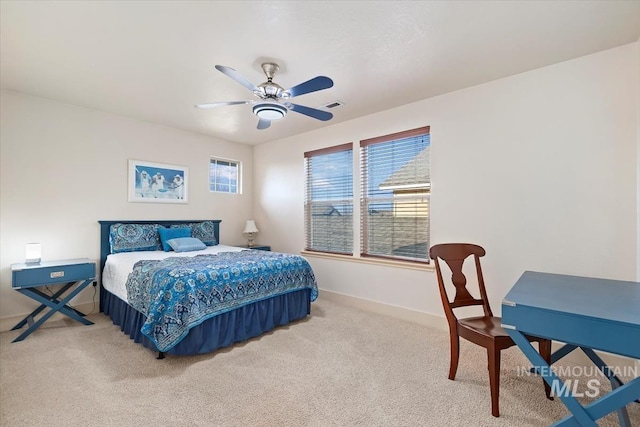 bedroom featuring multiple windows, ceiling fan, and light carpet