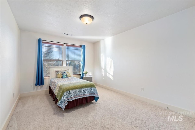 carpeted bedroom featuring a textured ceiling