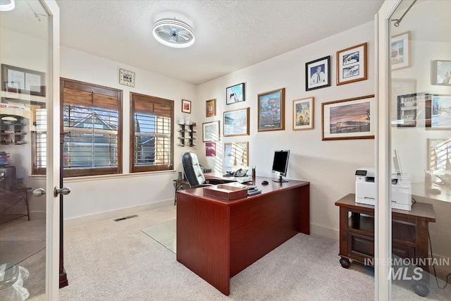 office featuring light colored carpet and a textured ceiling