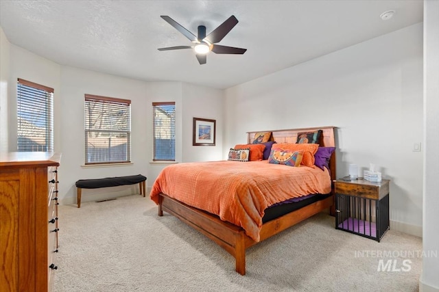 bedroom with ceiling fan and light carpet