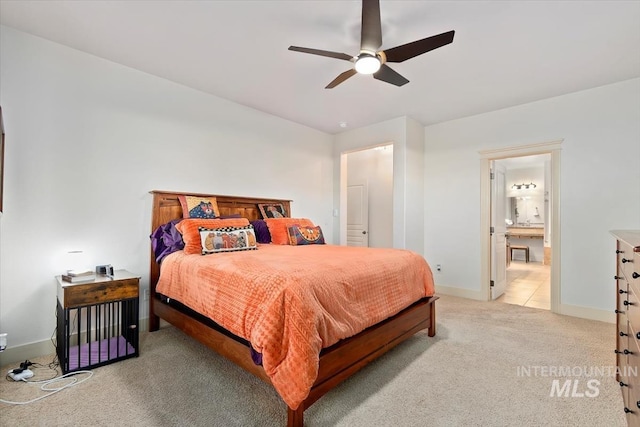 carpeted bedroom with ensuite bath and ceiling fan